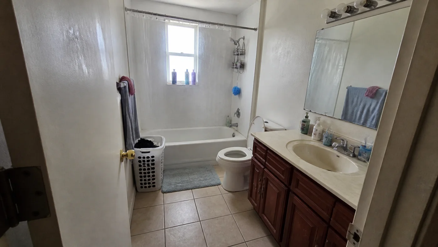 Before: Before and after comparison of a compact bathroom and a warm stone and oak redesign